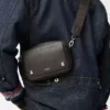 Bolso mensajero pequeño Pebble en piel de becerro granulada flexible Gris oscuro Bolso mensajero pequeño Pebble en piel de becerro granulada flexible Gris oscuro