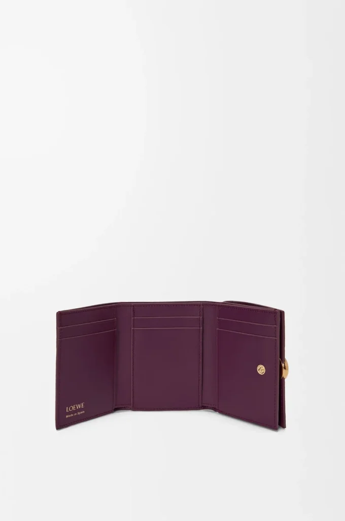 Cartera plegable de tres pliegues en piel de becerro granulado color ciruela Cartera plegable de tres pliegues en piel de becerro granulado color ciruela