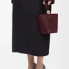 Mini bolso tipo cubo Pebble en piel de becerro lisa Dark Burgundy Mini bolso tipo cubo Pebble en piel de becerro lisa Dark Burgundy